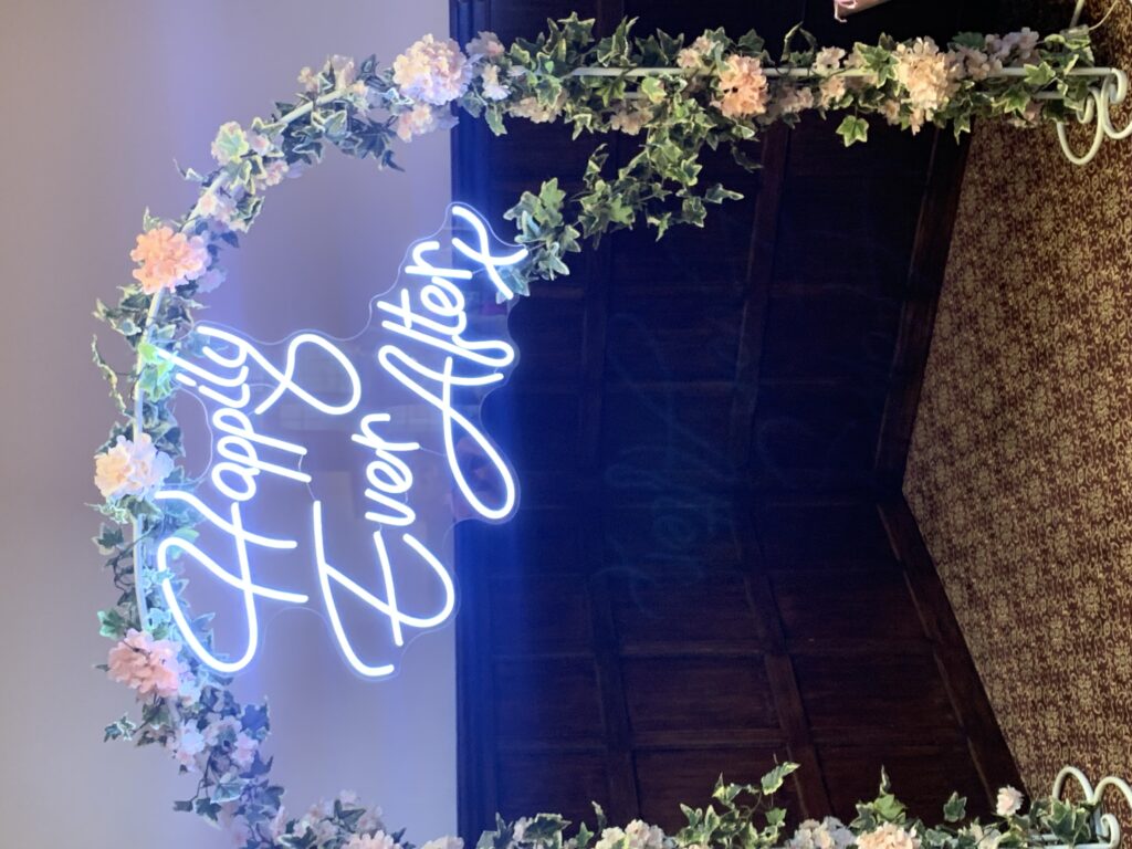 Happily Ever After Neon Sign on a decorated floral arch
